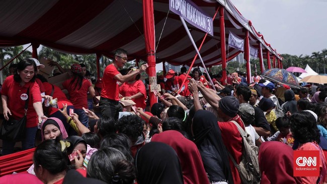 Banyak perempuan dan anak-anak terhimpit saat antre sembako Pesta Rakyat di Monas. Ada juga warga yang baku pukul dan beradu mulut berebut tempat antrean.