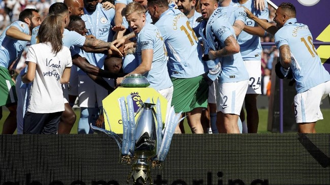 Kegembiraan pemain Manchester City dalam perayaan pesta juara hampir berakhir tragis lantaran trofi Liga Primer Inggris terjatuh dari panggung.
