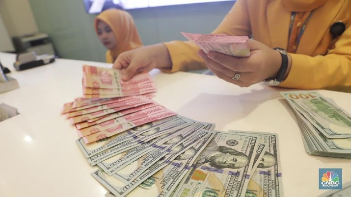 Ilustrasi Rupiah dan Dollar di teller Bank Mandiri, Jakarta, Senin (07/5). Nilai tukar rupiah terhadap dolar Amerika Serikat (AS) masih melemah. Rupiah melemah 0,32 % dibandingkan penutupan akhir pekan lalu. Harga jual dolar AS di bank Mandiri Rp. 14.043. (CNBC Indonesia/Muhammad Sabki)