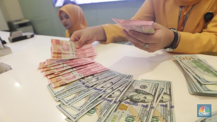 Ilustrasi Rupiah dan Dollar di teller Bank Mandiri, Jakarta, Senin (07/5). Nilai tukar rupiah terhadap dolar Amerika Serikat (AS) masih melemah. Rupiah melemah 0,32 % dibandingkan penutupan akhir pekan lalu. Harga jual dolar AS di  bank Mandiri Rp. 14.043. (CNBC Indonesia/Muhammad Sabki)