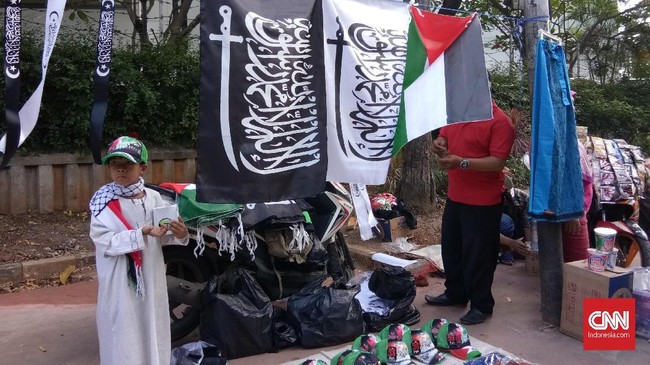 Mulia dan seorang warga Filipina menjajakan dagangan di tengah Aksi 115, yang sebagian keuntungannya akan mereka berikan kepada rakyat Palestina.