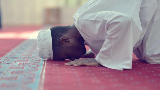 African Muslim Man Making Traditional Praying To God While Wearing A Traditional Cap Dishdasha