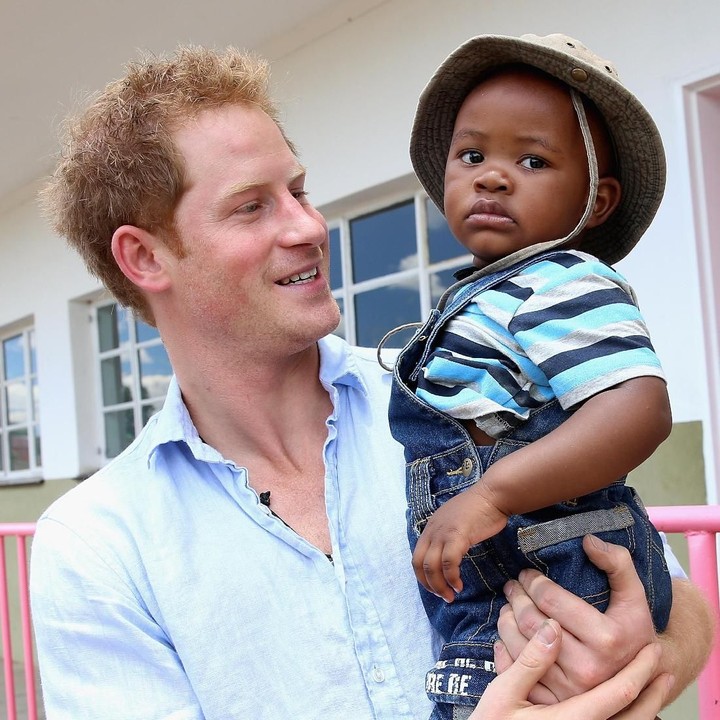 <p>Menggendong anak kecil memang hal biasa bagi Pangeran Harry yang sering melakukan kunjungan kemanusiaan. (Foto: Getty Images)</p>