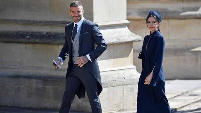 'Meghan Markle' ala Victoria Beckham di Nikahan Sergio Ramos Untuk menghadiri pesta pernikahan Sergio Ramos di Spanyol, Victoria memilih gaun panjang bergaya mermaid berkerah tinggi dan heels pink cerah.