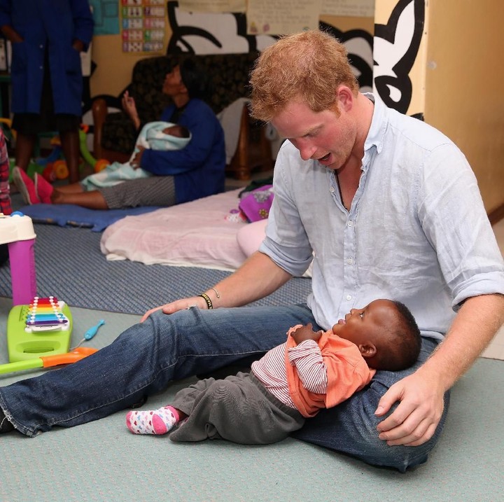 <p>Santai banget Pangeran Harry bersama seorang bocah dari Lesotho ini. Udah PW alias posisi wenak ya, Nak? He-he. (Foto: Getty Images)</p>