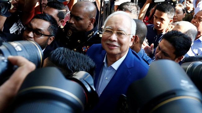 Tak ditahan, mantan PM Malaysia meninggalkan gedung komisi anti-korupsi usai menjalani pemeriksaan perdana terkait skandal 1MDB.