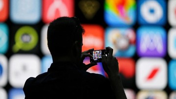 A visitor uses his iPhone X to take photos of the stage at the Apple Worldwide Developer conference in San Jose, California, U.S., June 4, 2018.   REUTERS/Elijah Nouvelage