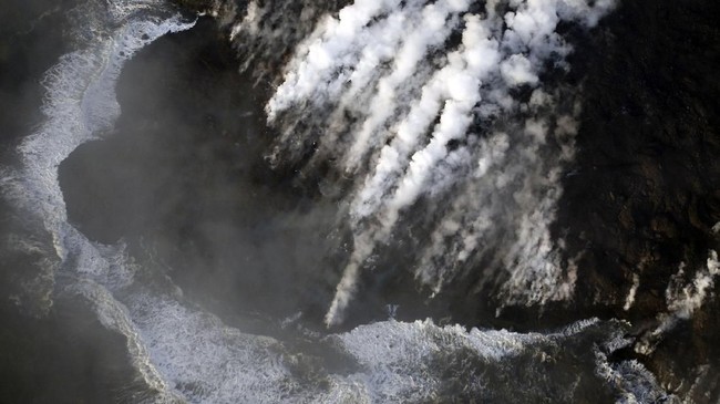 Kabut uap membumbung dari danau air tawar terbesar Hawaii saat aliran lava menguapkan airnya hingga habis dalam hitungan beberapa jam.