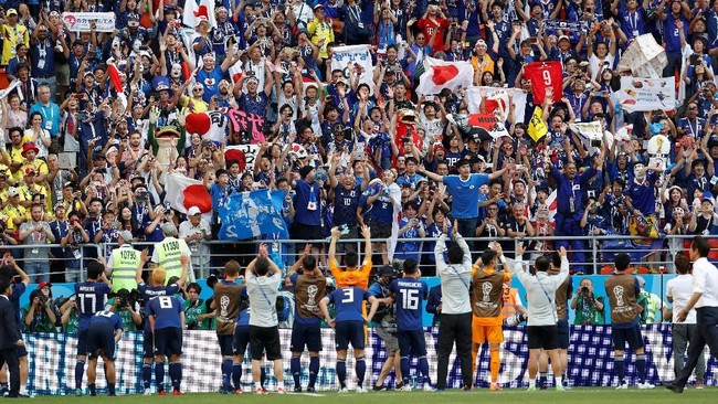 Suporter timnas Jepang membersihkan sampah di sekitar Stadion Mordovia Arena usai tim mereka mengalahkan Kolombia pada fase grup Piala Dunia 2018.