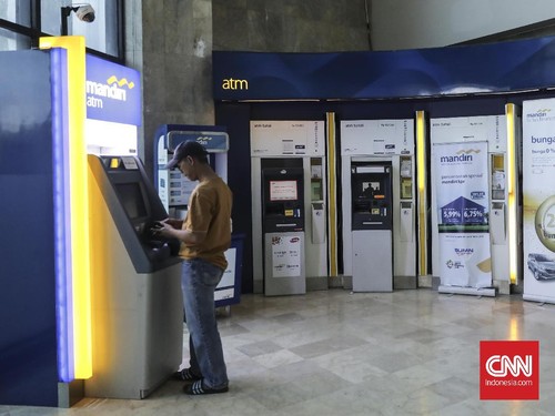 Nasabah melakukan transaksi di mesin Atm cabang Bank Mandiri Gambir pada saat libur lebaran, Jakarta (20/6). Per tanggal 21 Juni 2018, seluruh kantor cabang Bank Mandiri sudah beroperasi secara menyeluruh. (CNN Indonesia/ Hesti Rika)