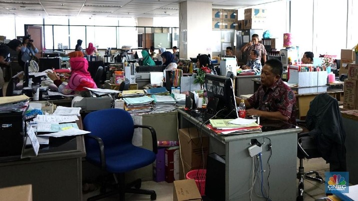 Pegawai balai kota melakukan aktivitas setelah libur lebaran  di Kantor Balaikota, Jakarta, Kamis (21/6). Hari pertama bekerja usai libur lebaran Idul Fitri 2018 ini, Pemprov DKI Jakarta melaksanakan acara halal bihalal bersama Gubernur dan Wakil Gubernur DKI Jakarta. Pagi ini terlihat antrian pegawai negeri sipil (PNS) sudah mengular hingga keluar Pendopo Balaikota. Pemerintah akan memberikan sanksi bagi PNS yang membolos di hari pertama kerja tersebut. Sanksi tersebut antara lain berupa teguran lisan bagi mereka yang tidak masuk kerja sampai dengan 5 hari kerja. Teguran tertulis bagi PNS yang tidak masuk kerja tanpa alasan yang sah selama 6 sampai dengan 10 hari kerja. (CNBC Indonesia/Muhammad Sabki)