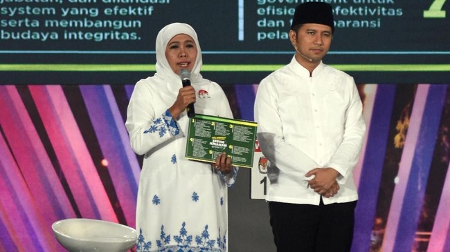 Khofifah Indra Parawansa menang telak di TPS tempatnya mencoblos dan kini pasangan Emil Dardak itu sibuk meladeni wartawan usai menang versi quick count suvei.