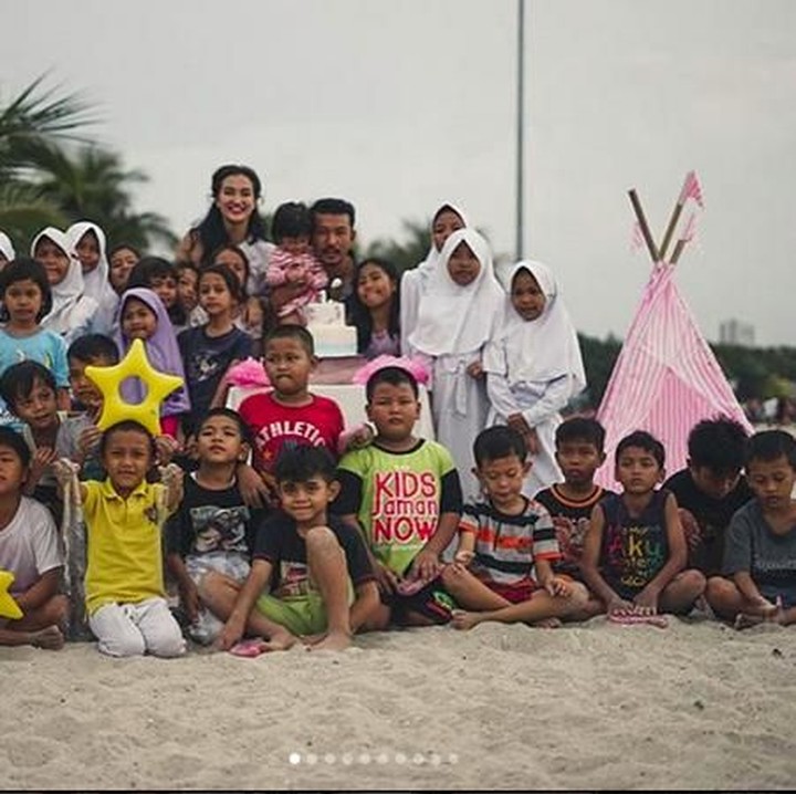 <p>Mereka merayakannya bersama anak-anak di pantai. (Foto: Instagram @atiqahhasiholan)</p>