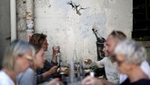 FOTO: Coretan Kritis Banksy di Prancis Seniman mural Banksy membuat serial coretan di Bataclan, Prancis. Setiap karya yang digambarnya menyiratkan kritik terhadap pemerintah negara itu.