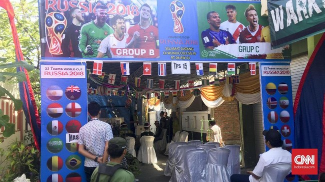 Warga menghias segala atribut Piala Dunia di Tempat Pemungutan Suara (TPS) 15 RT 06/RW 04, Wonocolo, Surabaya, Jawa Timur.