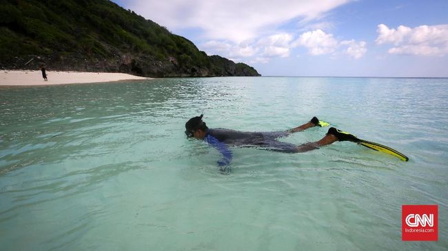 Tak jauh dari Makam Karang, terbentang pasir putih yang halus dengan beningnya air laut dan ombak yang tenang. Menghabiskan waktu berenang atau sekedar bermain di pantai yang sepi dan hening bak pantai pribadi. CNNIndonesia/Safir Makki