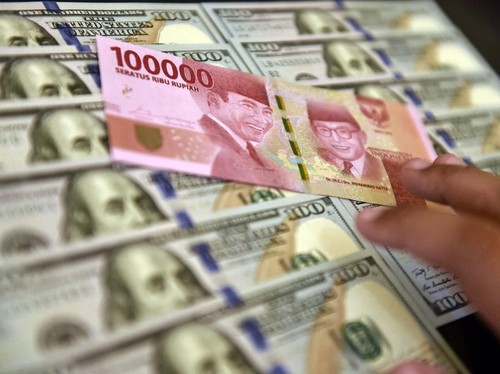 Lembaran mata uang rupiah dan dollar AS diperlihatkan di salah satu jasa penukaran valuta asing di Jakarta, Senin (2/7). Mata uang rupiah di pasar spot exchange berada di level Rp14.375 per dolar AS atau terdepresiasi 50 poin atau 0,35 persen dibandi