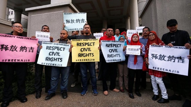Pendukung Najib Razak berkumpul sambil menyanyikan lagu 'Allah Selamatkan Kamu' sebelum sang mantan PM itu menghadiri sidang terkait skandal 1MDB, Rabu (4/7).