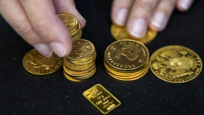 FILE PHOTO: A worker places gold coins on display at Hatton Garden Metals precious metal dealers in London, Britain July 21, 2015. REUTERS/Neil Hall/File Photo