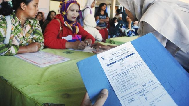 Kisruh Zonasi PPDB Guru memeriksa berkas murid baru saat daftar ulang Penerimaan Peserta Didik Baru (PPDB) di SMPN 1 Cimenyan, Kabupaten Bandung, Jawa Barat, Selasa (10/7). Sebanyak 70 persen murid baru diterima melalui sistem zonasi atau area domisili terdekat dengan sekolah sedangkan sisanya melalui nilai murni atau jalur SKTM. ANTARA FOTO/Heru Salim/agr/ama/18.