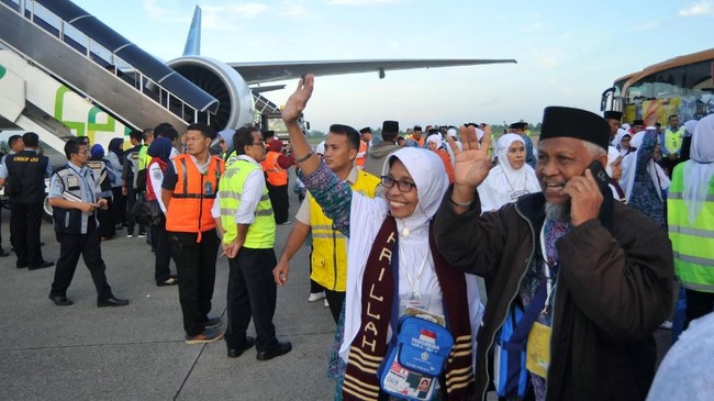 Jamaah calon haji melambaikan tangan kepada keluarga mereka, menjelang keberangkatan kloter pertama embarkasi Padang, di Bandara Internasional Minangkabau (BIM), Padangpariaman, Sumatera Barat, Selasa (17/7). Total calon jamaah haji yang berangkat melalui embarkasi Padang pada 2018 berjumlah 6.367 jemaah berasal dari Sumbar dan Bengkulu dan terbagi atas 17 kelompok terbang. ANTARA FOTO/Iggoy el Fitra/Spt/18
