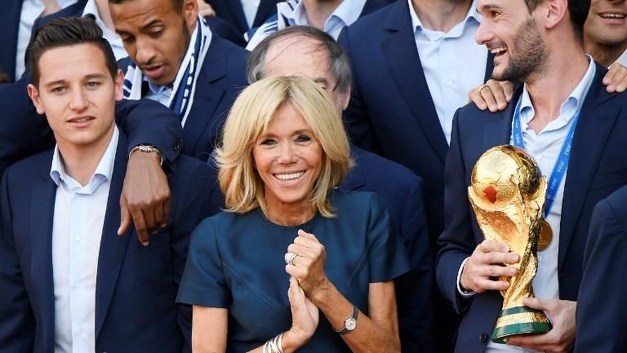 Emmanuel Macron dan Brigitte Macron French president Emmanuel Macron holding the trophy (C) and his wife Brigitte Macron (C-L), France's coach Didier Deschamps (5thR), France's goalkeeper Hugo Lloris (6thR) pose for a family photo at a reception for the French national football team after they won the Russia 2018 World Cup final football match at the Elysee Presidential Palace on July 16, 2018 in Paris.

France celebrated their second World Cup win 20 years after their maiden triumph on July 15, 2018, overcoming a passionate Croatia side 4-2 in one of the most gripping finals in recent history. / AFP PHOTO / Lionel BONAVENTURE