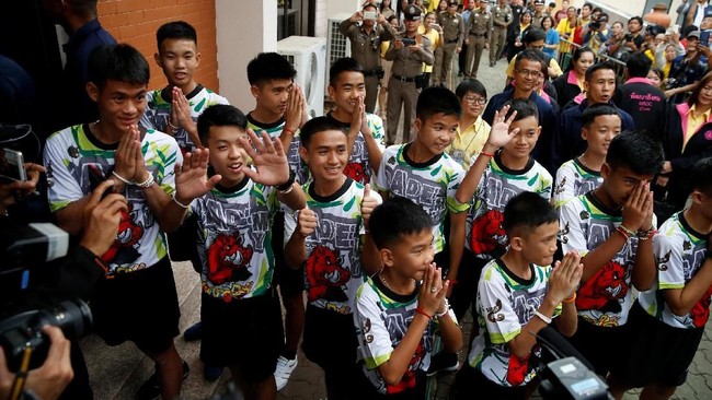 Belasan remaja dan pelatih sepak bola korban gua terbanjiri di Thailand melambaikan tangan, tersenyum dan menyampaikan salam dalam penampilan publik pertamanya.