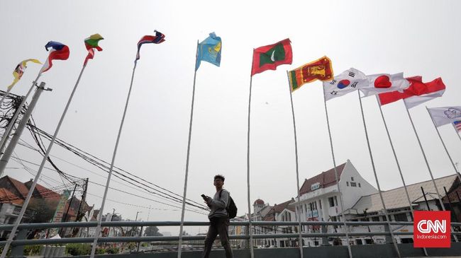 Bendera negara peserta Asian Games dipasang di Pluit dengan bambu seadanya, di sisi lain pemasang bendera pun tak paham dengan hajatan bernama Asian Games itu.