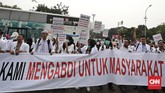 Puluhan orang yang tergabung dalam Pergerakan Dokter Muda Indonesia (PDMI) melakukan aksi unjuk rasa menuntut ijazah dokter mereka di seberang Istana Kepresidenan, depan pintu barat Monas, Jakarta Pusat,19 Juli 2018. (CNN Indonesia/Andry Novelino)