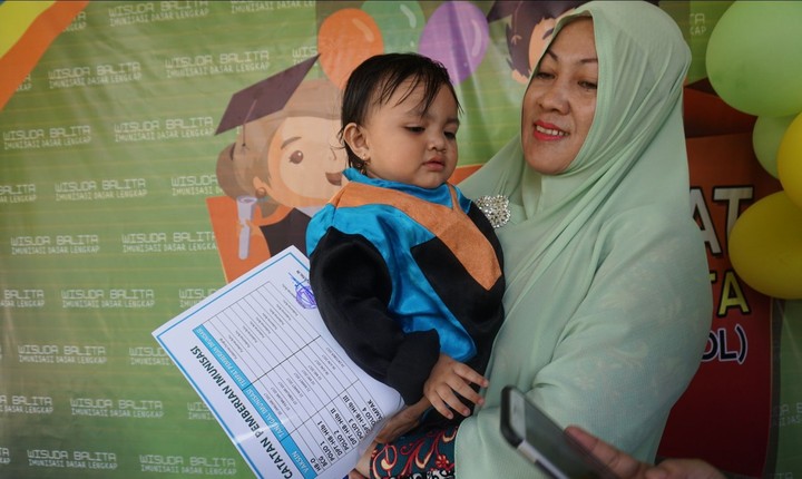 Kecil-kecil sudah diwisuda nih, Bun. Ini karena anak-anak tersebut lulus imunisasi dasar lengkap. Aih, lucunya anak-anak pakai toga.