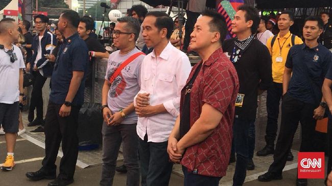 Jokowi datang mengenakan kemeja putih, jeans biru gelap dan sneaker hitam di acara We The Fest 2018 di JIExpo Kemayoran, Jakarta Pusat.