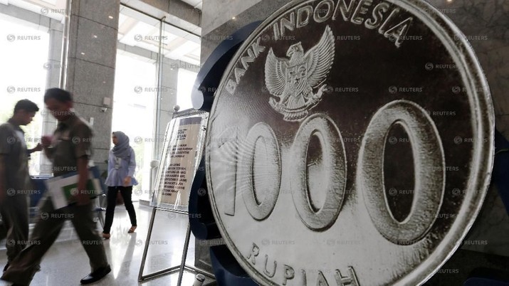 People walk past a mock one thousand Rupiah coin on display at Bank Indonesia's headquarters in Jakarta, Indonesia, November 17, 2016. REUTERS/Beawiharta/File Photo                  GLOBAL BUSINESS WEEK AHEAD PACKAGE       SEARCH BUSINESS WEEK AHEAD 12 DEC FOR ALL IMAGES