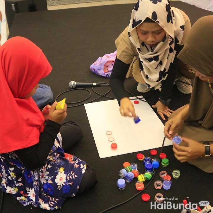 <p>Sibuk nih menempel tutup botol di papan karton.</p>