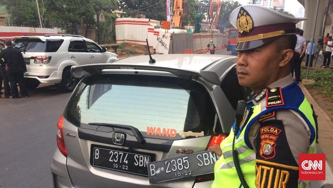 Seorang pengendara ditilang oleh polisi karena ketahuan memiliki dua plat palsu ganjil dan genap di hari pertama penilangan perluasan sistem ganjil genap.
