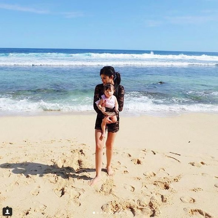 <p>Dita menggendong keponakannya main ke pantai. (Foto: Instagram @ditasoedarjo)</p>