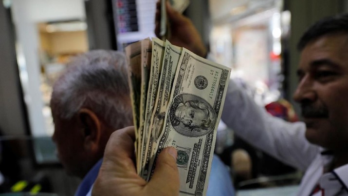 Businessmen change money at a currency exchange office in response to the call of Turkish President Tayyip Erdogan on Turks to sell their dollar and euro savings to support the lira, in Ankara, Turkey August 14, 2018. REUTERS/Umit Bektas