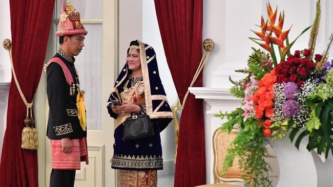 Iriana Jokowi memadukan warna biru dongker dengan benang sulam emas untuk busana adat asal Minangkabau yang dikenakannya di upacara 17 Agustus tahun ini.