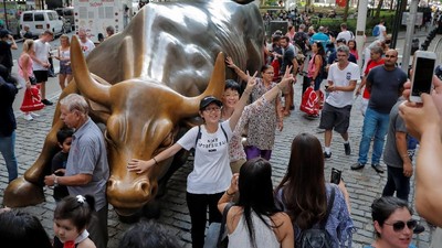 Tourists gather around the Charging Bull statue, also known as the Wall St. Bull, in the financial district of New York City, U.S., August 18, 2018. Picture taken August 18, 2018. REUTERS/Brendan McDermid