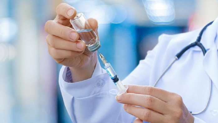 The doctor prepares the syringe with the cure for vaccination.