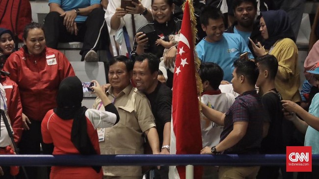 Penonton cabor pencak silat Asian Games 2019 ada yang kenakan kaus berwarna putih merah dan hitam. Kedua jenis kaus terpampang wajah Prabowo di bagian tengah.