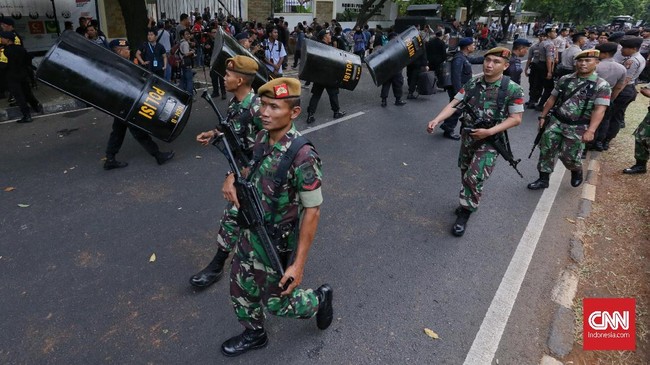Personel TNI dan Polri bersenjata laras panjang menjaga perimeter pengamanan di sepanjang kawasan Monas untuk mengawal karnaval deklarasi kampanye damai.