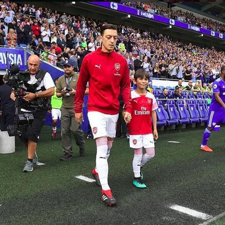 <p>Wah digandeng pemain Arsenal Mesut Ozil pastinya anak ini senang banget ya. (Foto: Instagram @juniorgunners)</p>