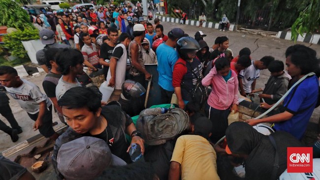 Warga Palu berdemo di posko Korem meminta bantuan dikirim langsung ke tenda pengungsian karena mereka tak memiliki BBM untuk mengangkut bantuan itu.