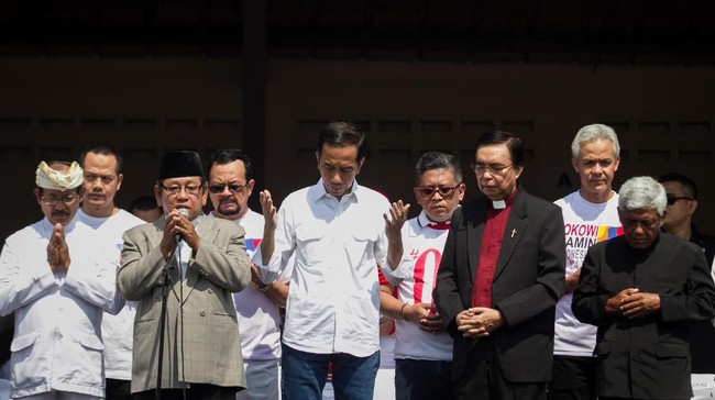 Calon Presiden no urut 01 Joko Widodo (tengah) bersama sejumlah tokoh lintas agama berdoa untuk korban gempa dan tsunami Palu di Stadion Sriwedari, Solo, Jawa Tengah, Minggu (30/9). Acara yang sedianya jalan sehat tersebut dibatalkan dan diganti dengan doa bersama sebagai bentuk empati dan keprihatinan atas bencana gempa dan tsunami di Sulawesi Tengah. ANTARA FOTO/Mohammad Ayudha/foc/18.