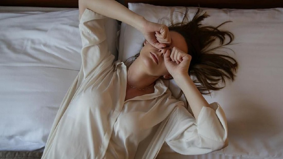 Young woman waking up, top view