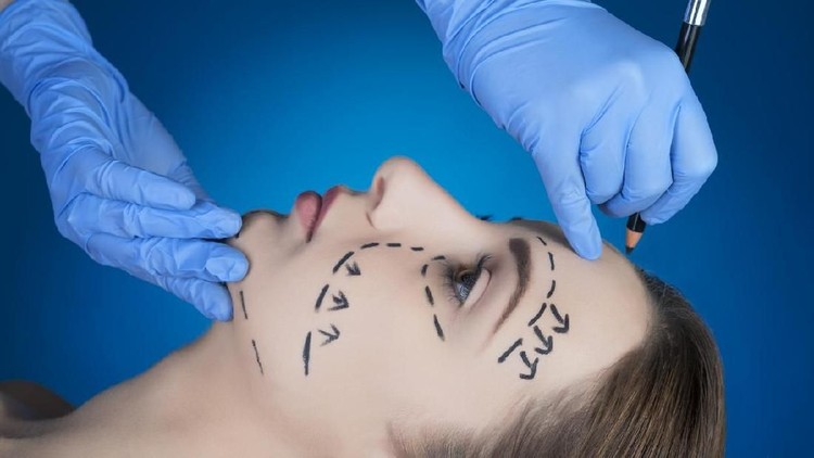 Close-up Of A Surgeon Drawing Perforation Lines On Young Woman's Face For Plastic Surgery