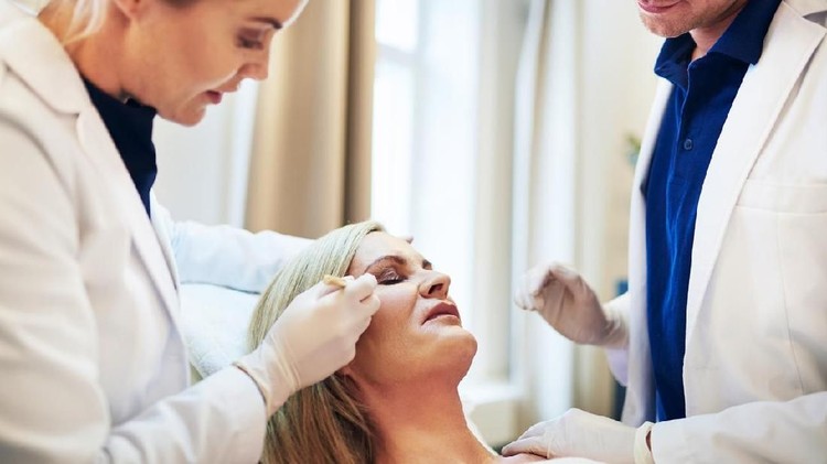 Close-up Of A Surgeon Drawing Perforation Lines On Young Woman's Face For Plastic Surgery