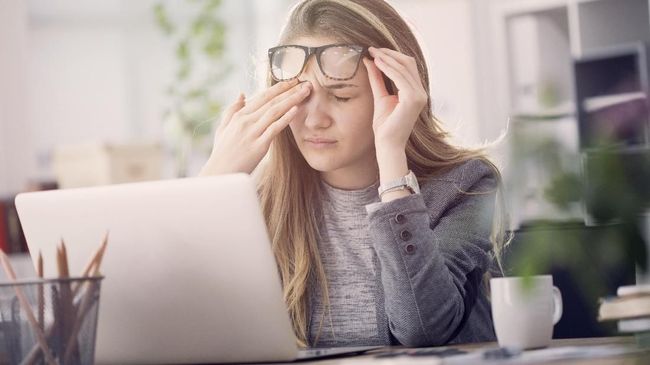 Young tired working woman at work