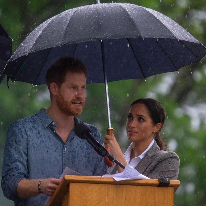 <p>Meghan pun nggak kalah romantis ke sang suami. Ketika Pangeran Harry berpidato dan diguyur hujan, dia dengan setia memayungi suami tercinta. Lihat deh pandangan Meghan. Aaw.. (Foto: Ian Vogler-Pool/Getty Images)</p>