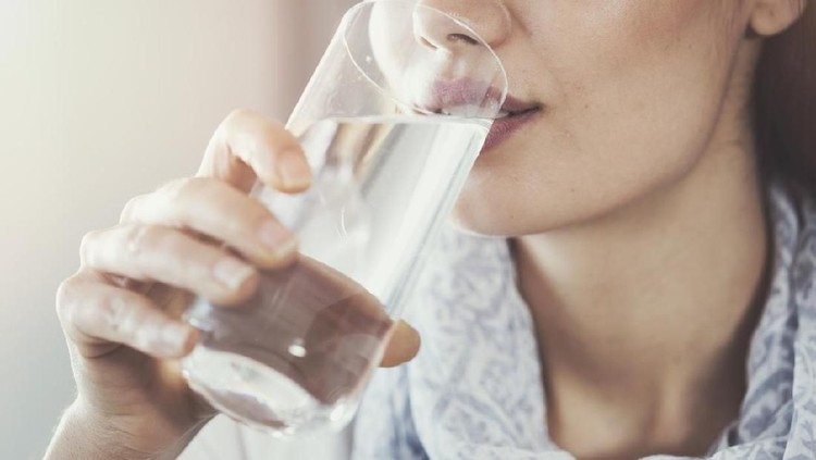 A child is drinking clean water from a bottle. Hot summer day.